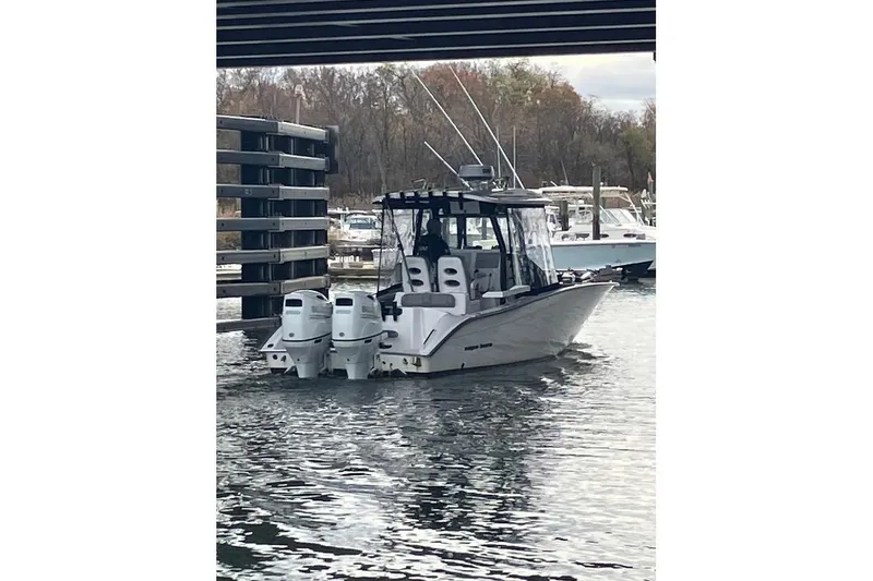 Slide: The Image of 2023 Cape Horn 27 XS boat docked in a marina, surrounded by water and other boats. - 6