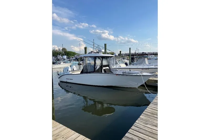 Slide: The Image of 2023 Cape Horn 27 XS boat docked at a marina under clear blue skies. - 7