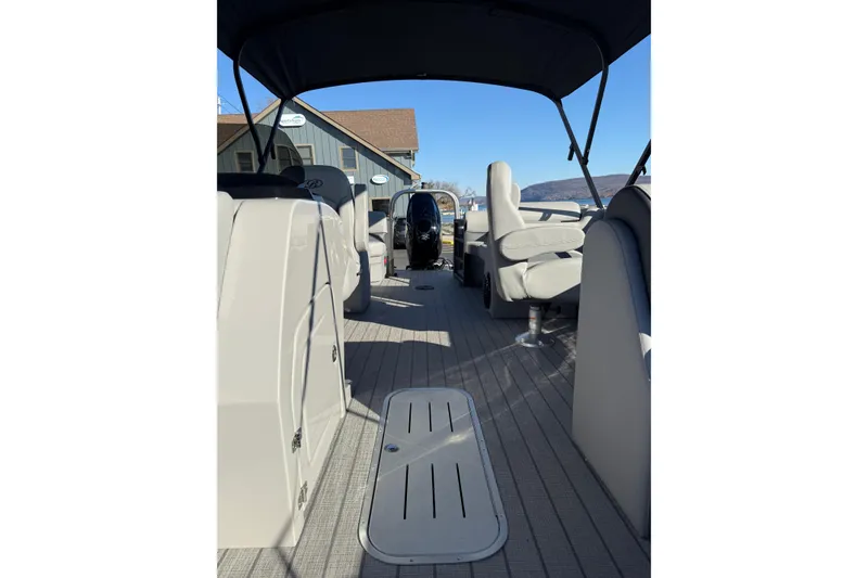 Slide: The Image of 2026 Bentley Pontoons Legacy 223 Navigator interior with seating and helm, docked under clear sky. - 7