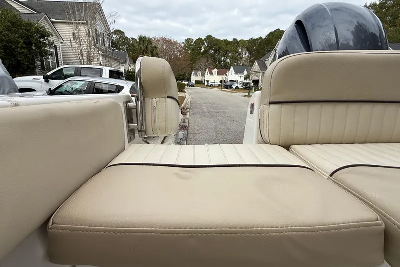 Slide: The Image of 2017 Sea Fox 226 Commander boat interior with beige seating, parked in a residential area. - 17