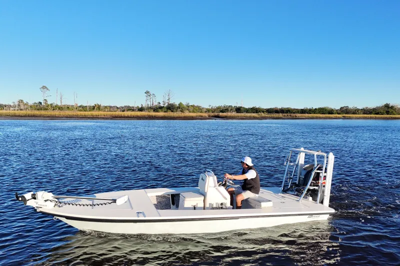 Slide: The Image of 2019 Maverick 18 HPX-V boat cruising on a calm river under clear blue skies. - 23