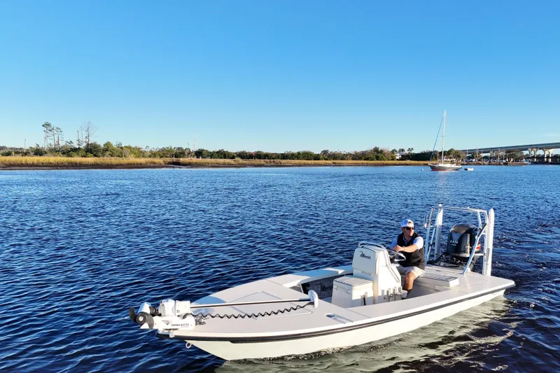 Slide: The Image of 2019 Maverick 18 HPX-V boat cruising on a calm river under a clear blue sky. - 24
