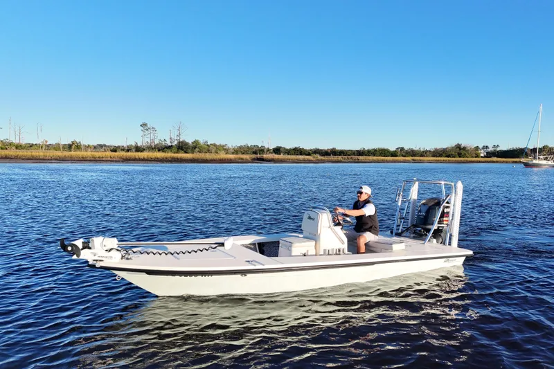 Slide: The Image of 2019 Maverick 18 HPX-V boat cruising on a calm river under a clear blue sky. - 26