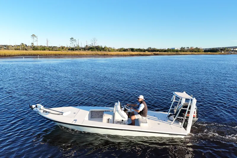 Slide: The Image of 2019 Maverick 18 HPX-V boat cruising on a calm river under clear blue skies. - 31
