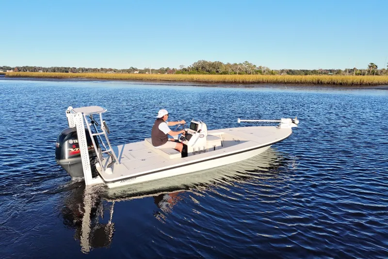 Slide: The Image of 2019 Maverick 18 HPX-V boat cruising on a calm river under clear blue skies. - 33