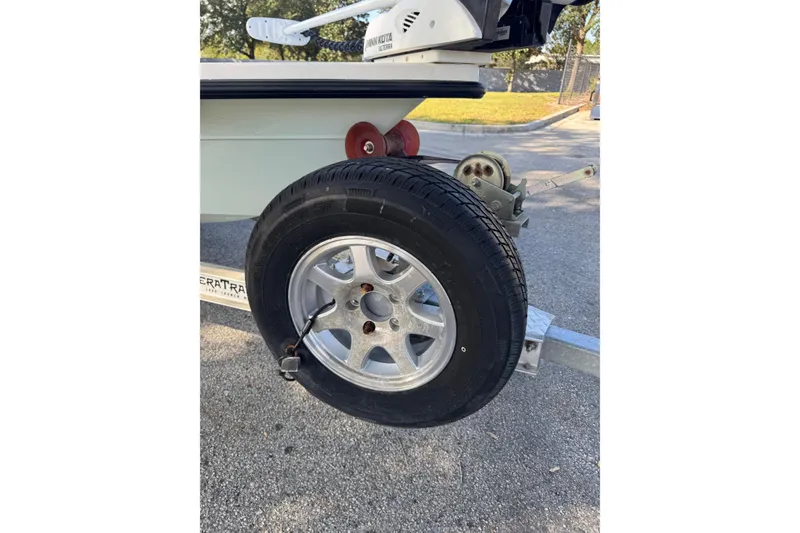 Slide: The Image of 2019 Maverick 18 HPX-V trailer wheel with Minn Kota motor, parked on pavement. - 78