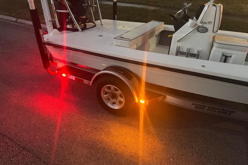 Slide: The Image of 2019 Maverick 18 HPX-V boat on trailer with illuminated rear lights at dusk. - 80