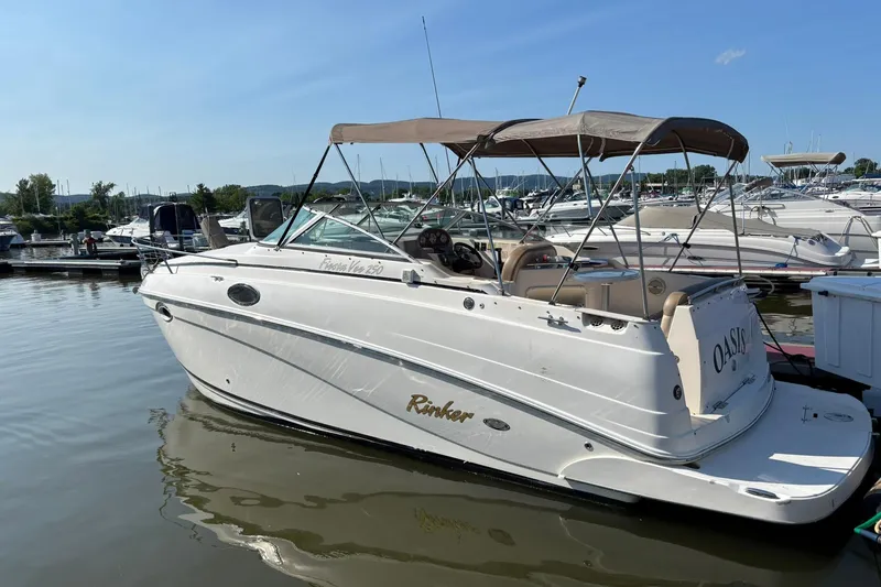 The Image of 2005 Rinker Fiesta Vee 250 boat docked in a marina on a sunny day. - 0