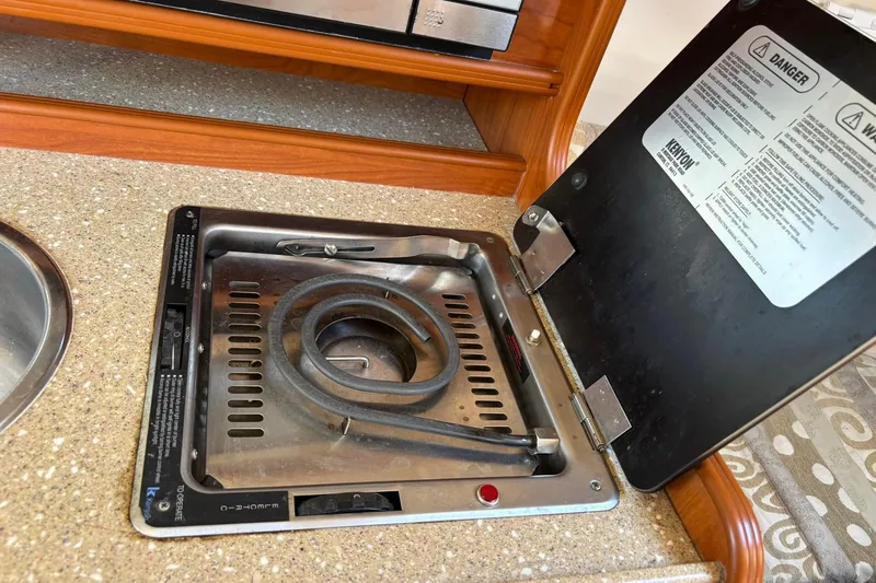 Slide: The Image of 2005 Rinker Fiesta Vee 250 boat stove with open lid and coiled burner. - 10