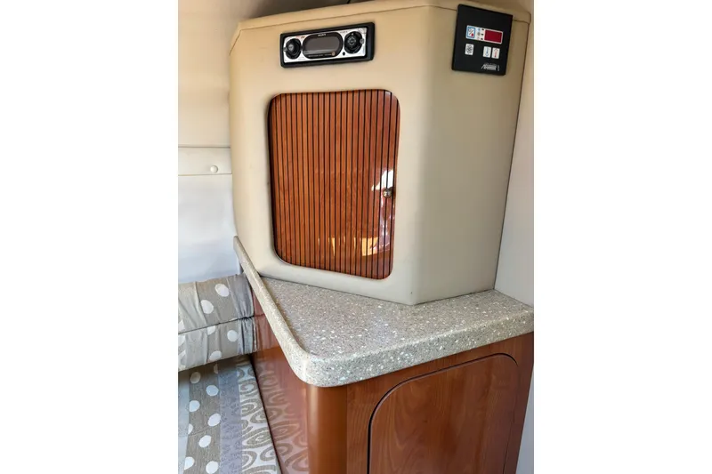 Slide: The Image of 2005 Rinker Fiesta Vee 250 cabin interior with wood paneling and control panel. - 13