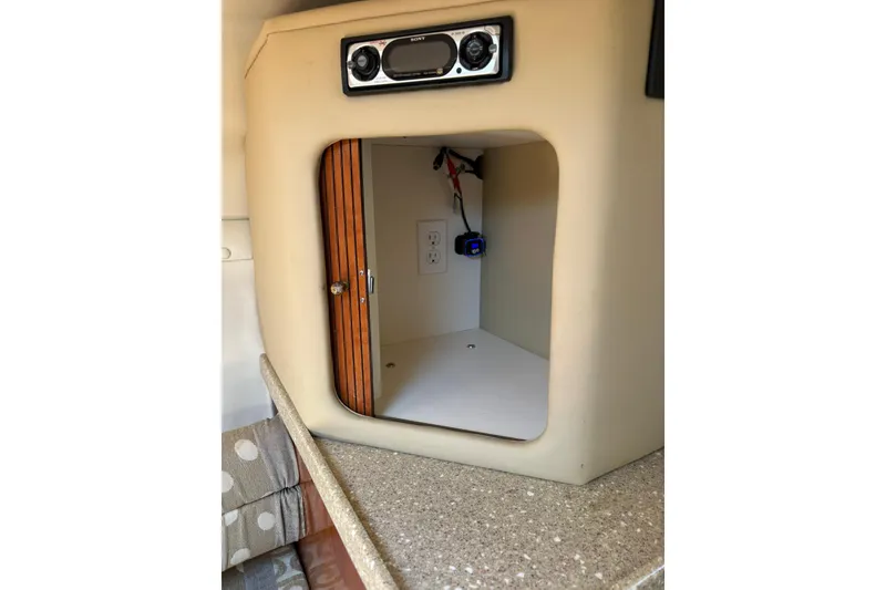 Slide: The Image of 2005 Rinker Fiesta Vee 250 cabin interior with stereo and storage compartment. - 14