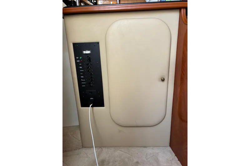 Slide: The Image of 2005 Rinker Fiesta Vee 250 control panel with beige cabinet and wood trim. - 19