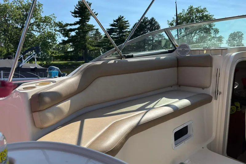 Slide: The Image of 2005 Rinker Fiesta Vee 250 boat interior with beige seating and cup holders. - 6