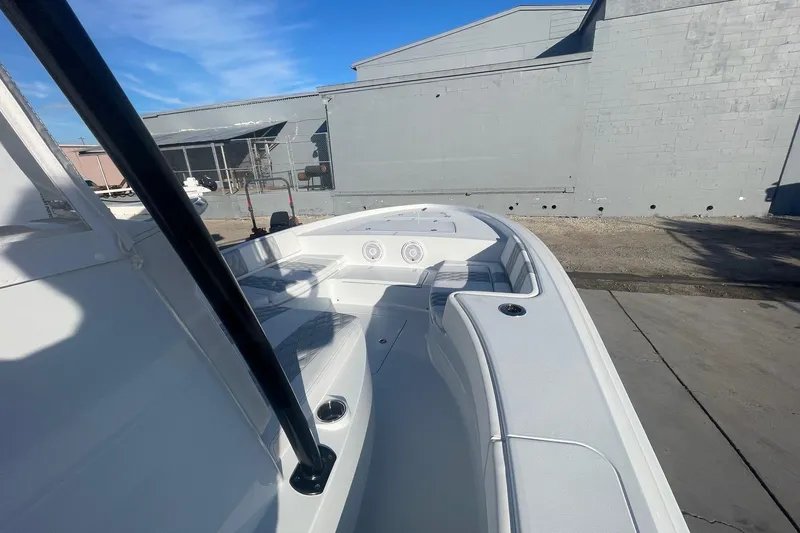 Slide: The Image of 2026 Contender 29 Bay boat interior with seating and storage, docked outdoors. - 17