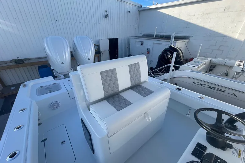 Slide: The Image of 2026 Contender 29 Bay boat with dual engines and cushioned seating in a marina setting. - 25