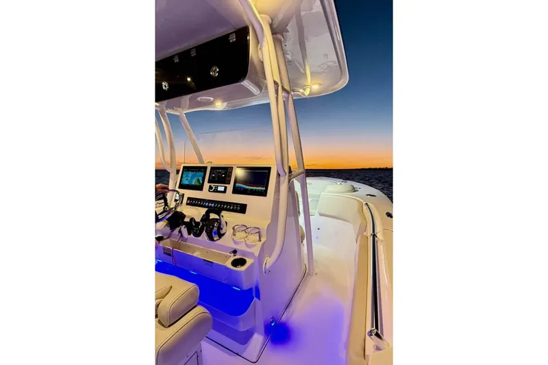Slide: The Image of 2022 Key West 263 FS boat interior with illuminated dashboard at sunset. - 13