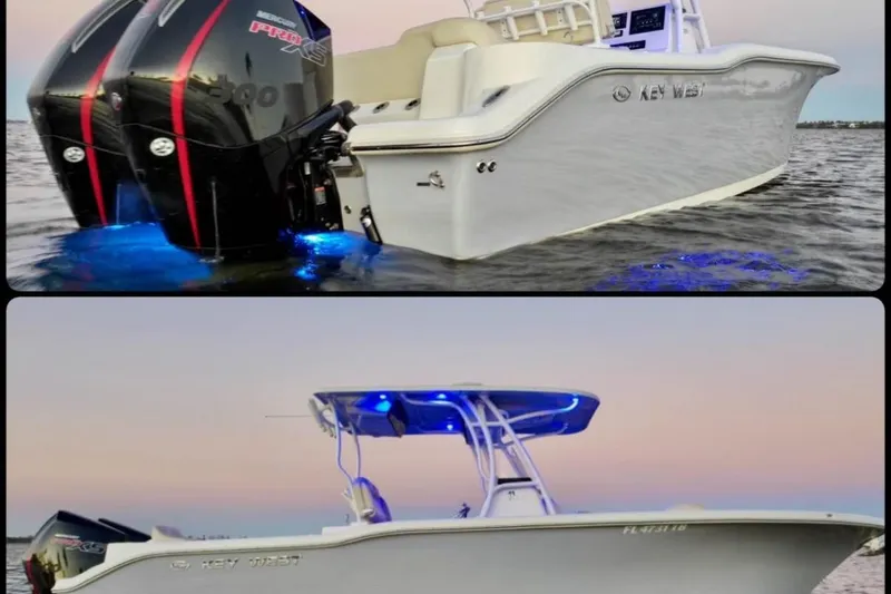 Slide: The Image of 2022 Key West 263 FS boat with dual engines and blue LED lights on water. - 2