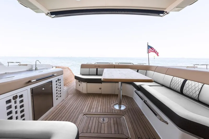 Slide: The Image of 2021 Sea Ray SLX 400 boat interior with elegant seating at a marina dock. - 13