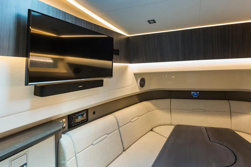 Slide: The Image of 2021 Sea Ray SLX 400 yacht interior with wooden table and cushioned seating. - 20