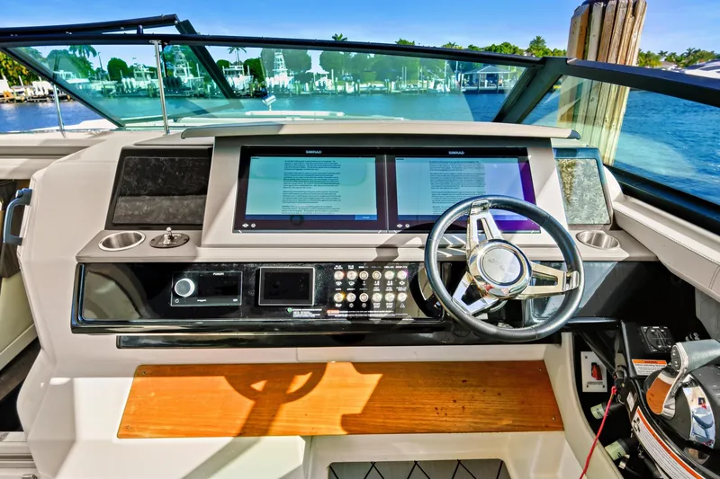 Slide: The Image of Helm of 2021 Sea Ray SLX 400 with dual screens and modern controls. - 23