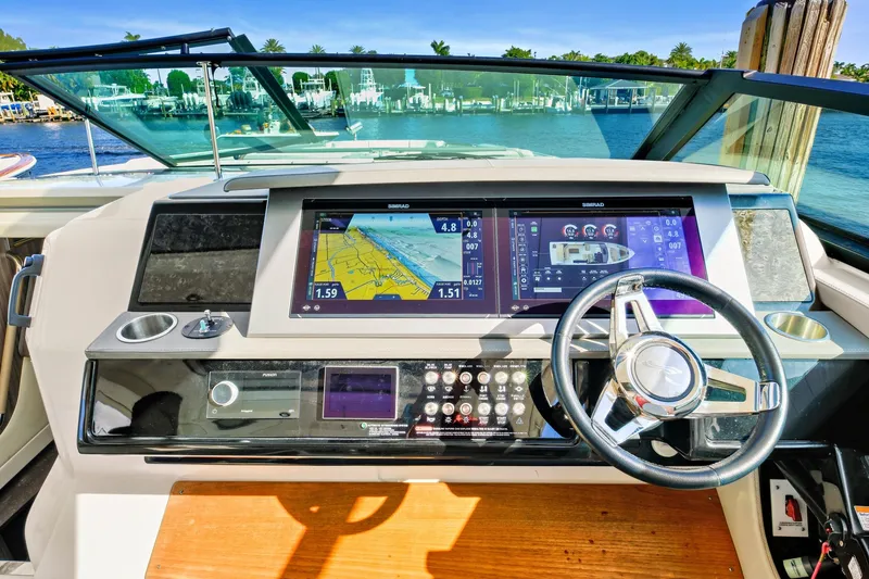 Slide: The Image of Dashboard of 2021 Sea Ray SLX 400 boat with navigation screens and steering wheel. - 24