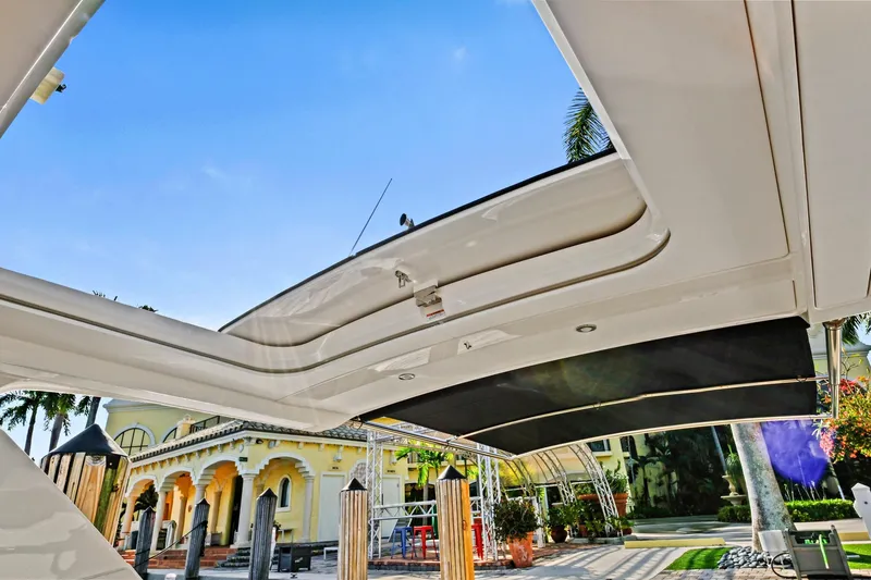 Slide: The Image of 2021 Sea Ray SLX 400 boat with open sunroof, docked near a luxurious building. - 31