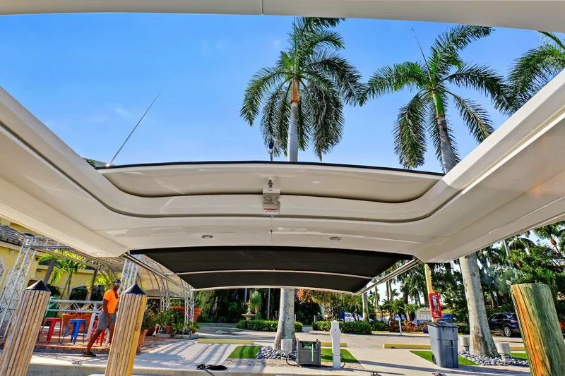 Slide: The Image of 2021 Sea Ray SLX 400 boat with open sunroof, palm trees in background. - 32
