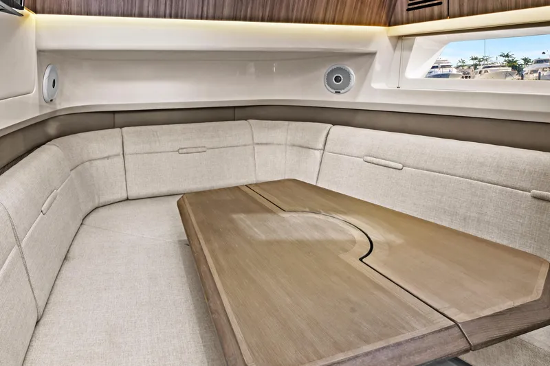 Slide: The Image of 2021 Sea Ray SLX 400 interior with beige seating and wooden table. - 39