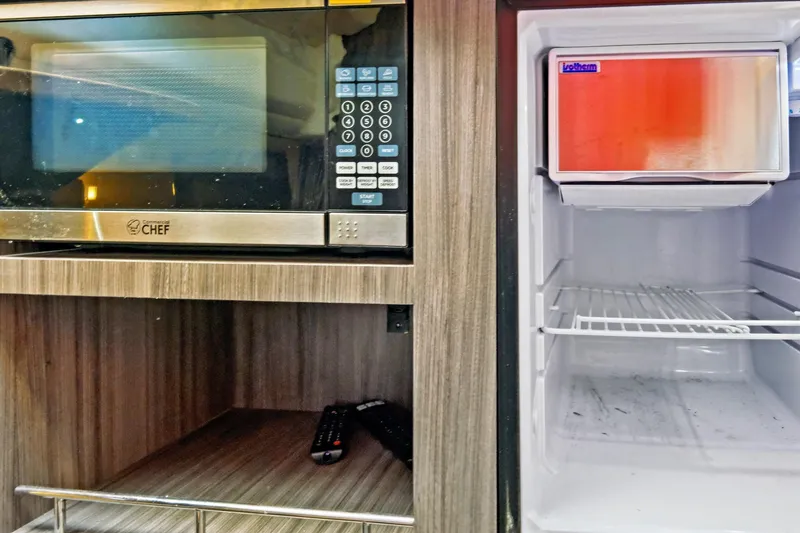 Slide: The Image of Microwave and mini fridge in 2021 Sea Ray SLX 400 boat interior. - 47