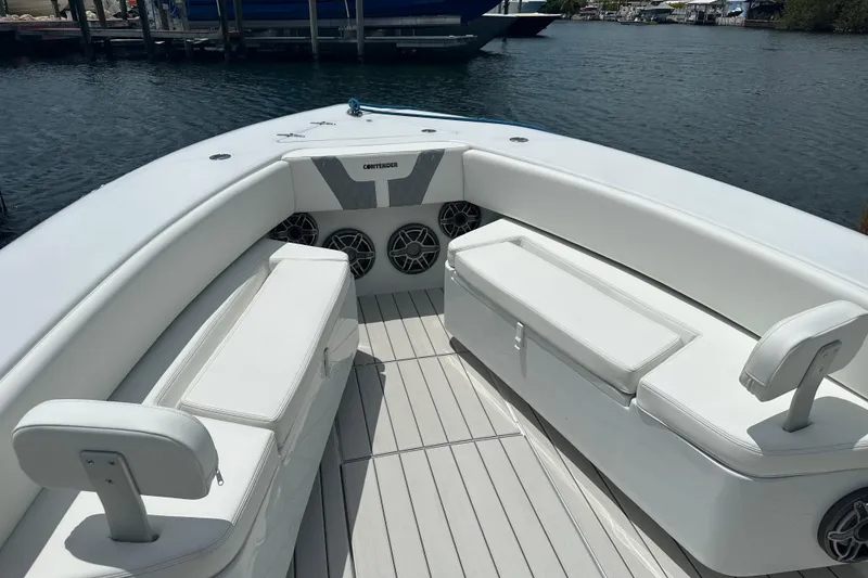 Slide: The Image of 2019 Contender 35 ST boat interior with white seating and speakers, docked by the water. - 19