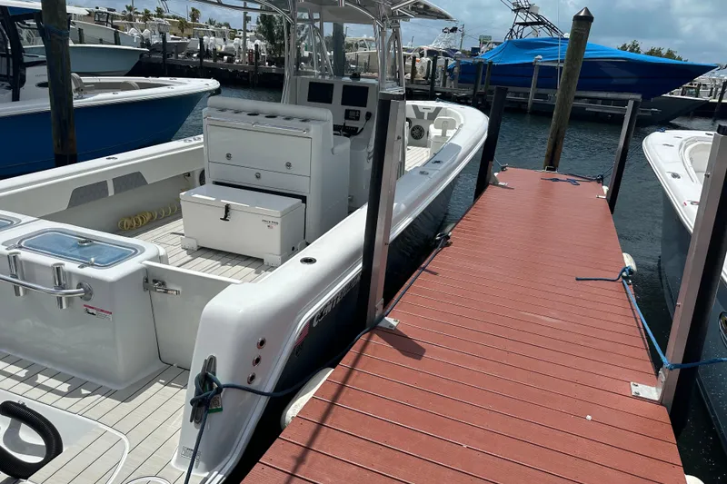 Slide: The Image of 2019 Contender 35 ST boat docked at marina with red wooden pier. - 25