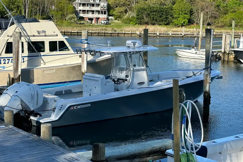 Slide: The Image of 2019 Contender 35 ST boat docked in a marina, featuring sleek design and powerful engines. - 31
