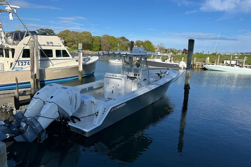 Slide: The Image of 2019 Contender 35 ST boat docked in a serene marina setting. - 32