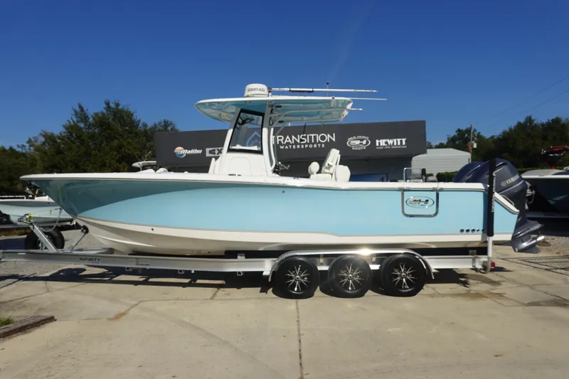The Image of 2018 Sea Hunt Gamefish 30 boat on trailer, displayed outdoors at a dealership. - 1