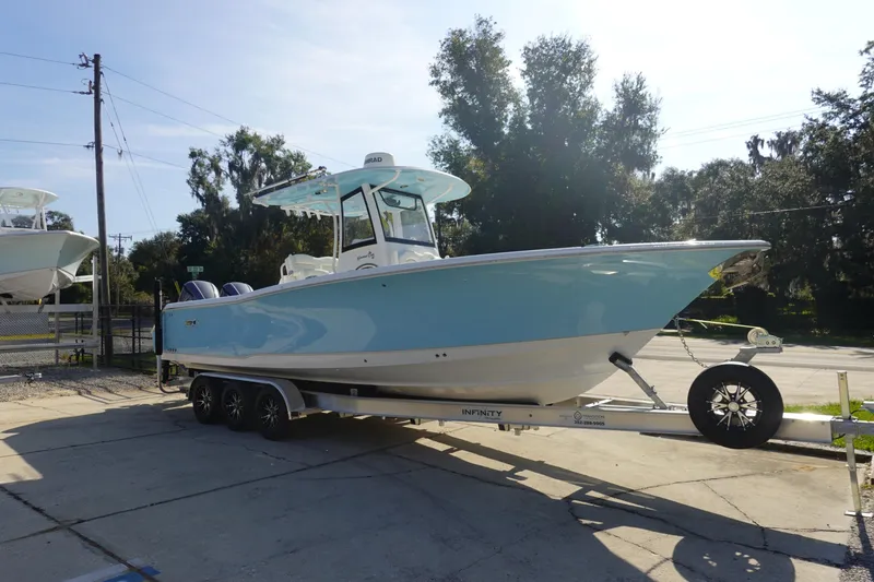 Slide: The Image of 2018 Sea Hunt Gamefish 30 boat on trailer, light blue hull, parked outdoors. - 3