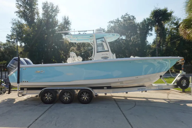 Slide: The Image of 2018 Sea Hunt Gamefish 30 boat on trailer, light blue hull, parked outdoors. - 4
