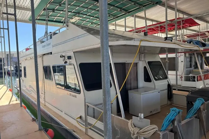 Slide: The Image of 2001 Myacht 4815 houseboat docked in a marina, featuring a covered upper deck. - 2