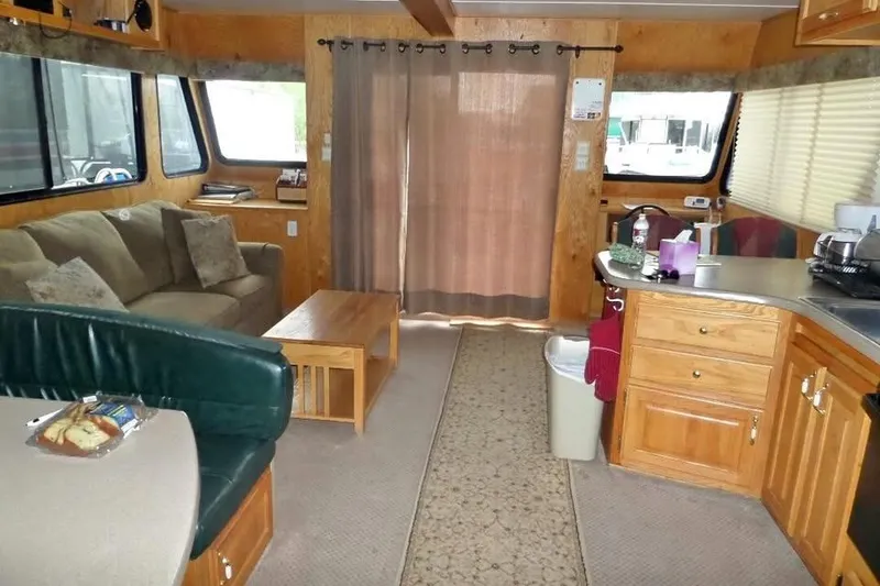 Slide: The Image of Interior of a 2001 Myacht 4815 houseboat with cozy seating and kitchen area. - 4