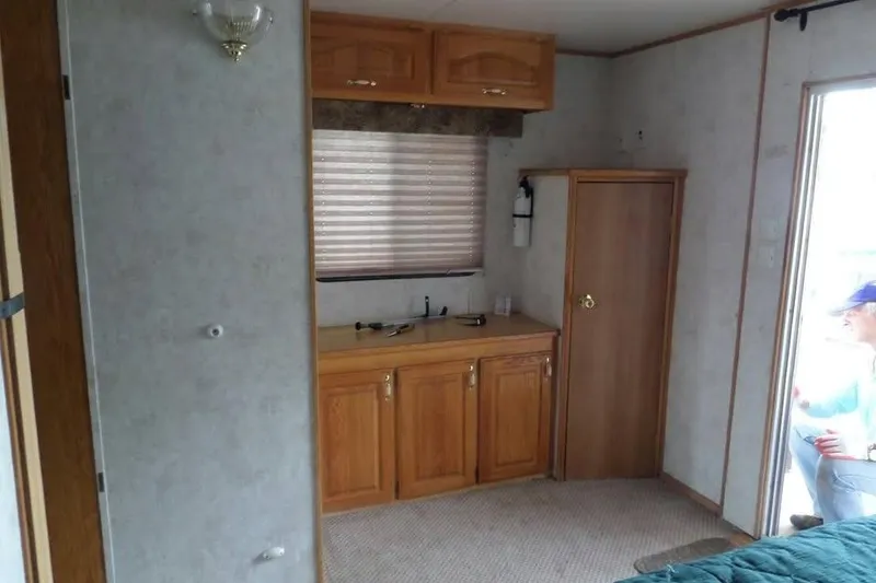 Slide: The Image of Interior of 2001 Myacht 4815 with wooden cabinets and a small sink area. - 5