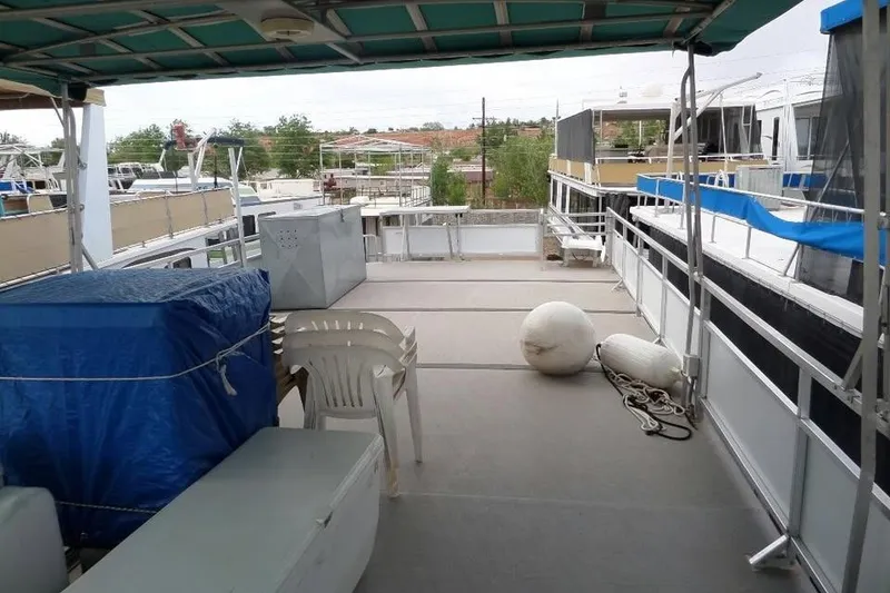 Slide: The Image of 2001 Myacht 4815 houseboat deck with chairs, covered storage, and docked surroundings. - 8