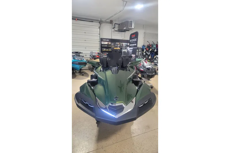 Slide: The Image of 2025 Kawasaki ULTRA 160LX jet ski in showroom, front view, green color. - 2