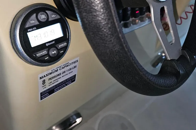 Slide: The Image of Steering wheel and radio of 2016 Barracuda 188 CCR boat, showing capacity label. - 8