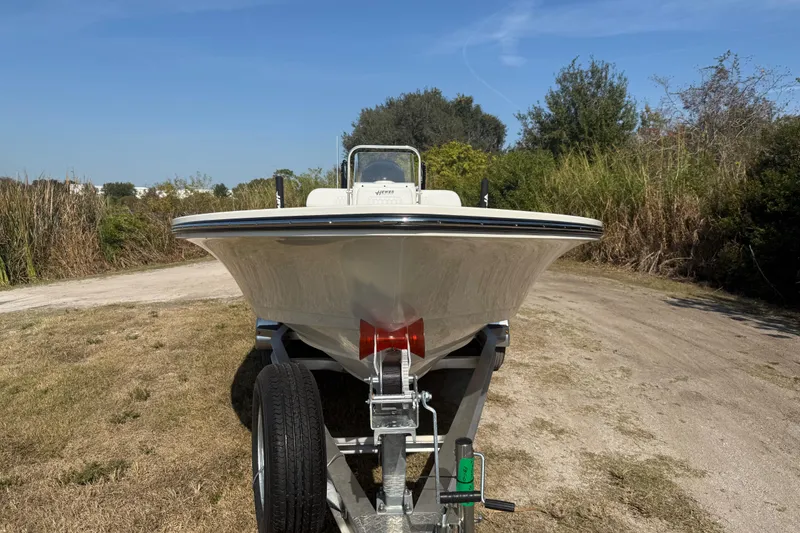 Slide: The Image of 2026 Hewes 21 REDFISHER boat on trailer, parked on grassy path. - 10