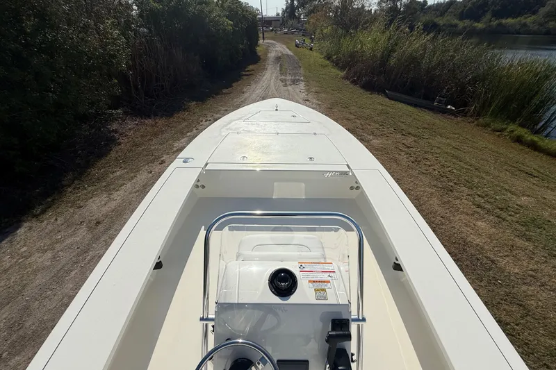 Slide: The Image of 2026 Hewes 21 REDFISHER boat on a grassy path near water. - 15
