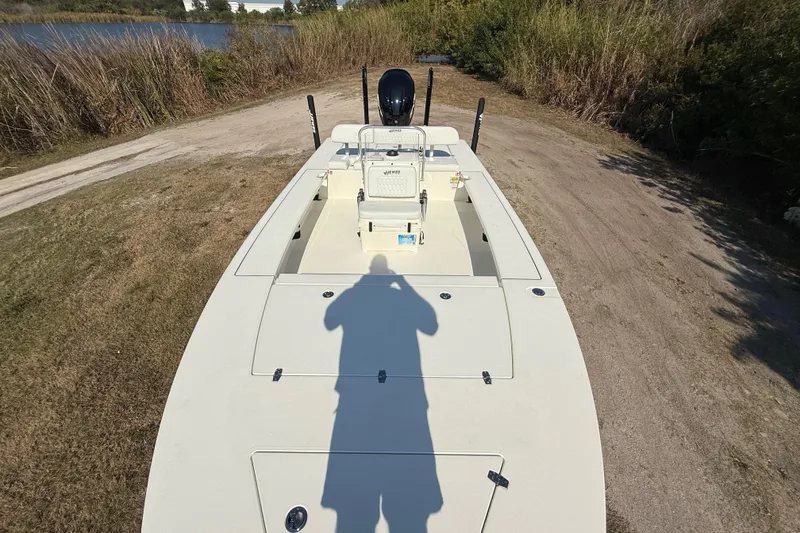 Slide: The Image of 2026 Hewes 21 REDFISHER boat on grassy terrain near a lake. - 18