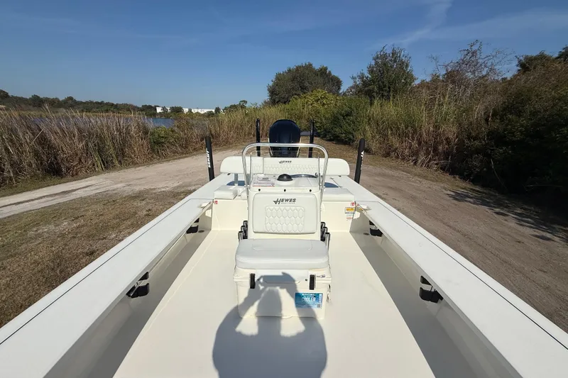 Slide: The Image of 2026 Hewes 21 REDFISHER boat on a grassy path near a lake. - 19