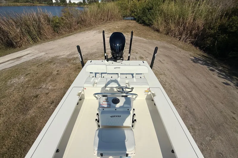 Slide: The Image of 2026 Hewes 21 REDFISHER boat on a grassy shore near a lake. - 20