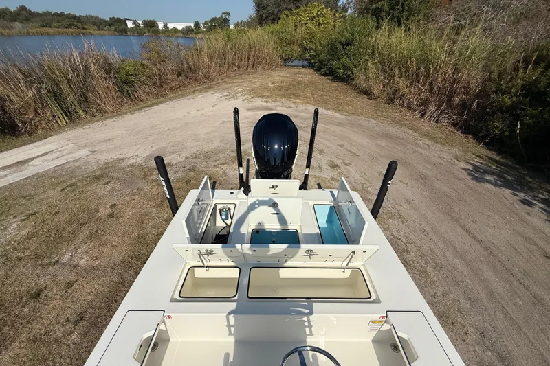 Slide: The Image of 2026 Hewes 21 REDFISHER boat on a grassy path near a lake. - 23
