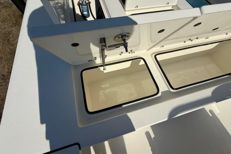 Slide: The Image of 2026 Hewes 21 REDFISHER boat storage compartments with open lids, showcasing interior space. - 25
