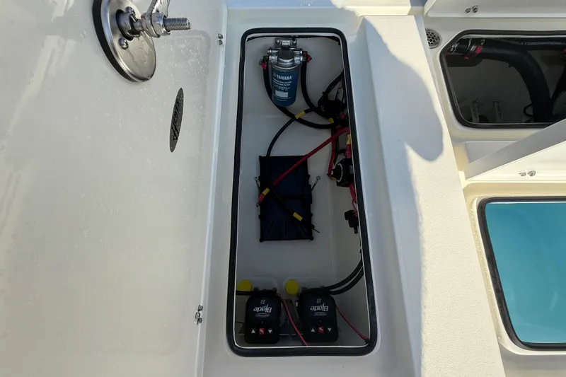 Slide: The Image of 2026 Hewes 21 REDFISHER boat compartment with wiring and battery setup. - 26